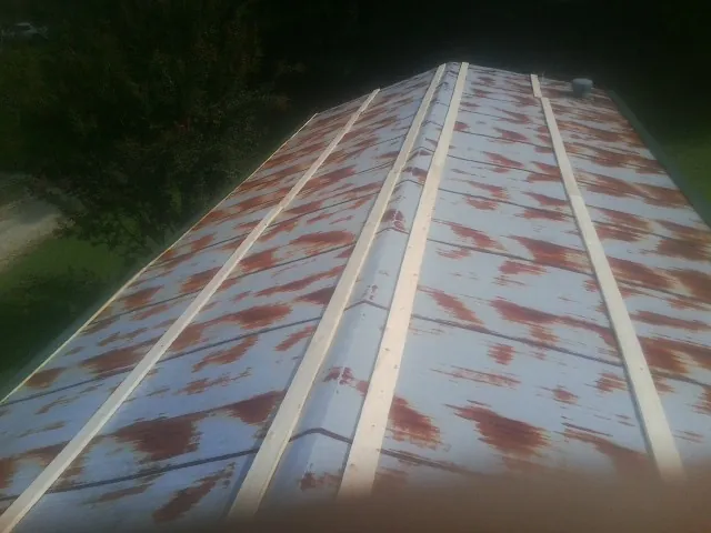 Rusted metal roof panels with new wood purlins before replacement — Storm Damage Roof Repair in Freeburg by Roofing Brothers