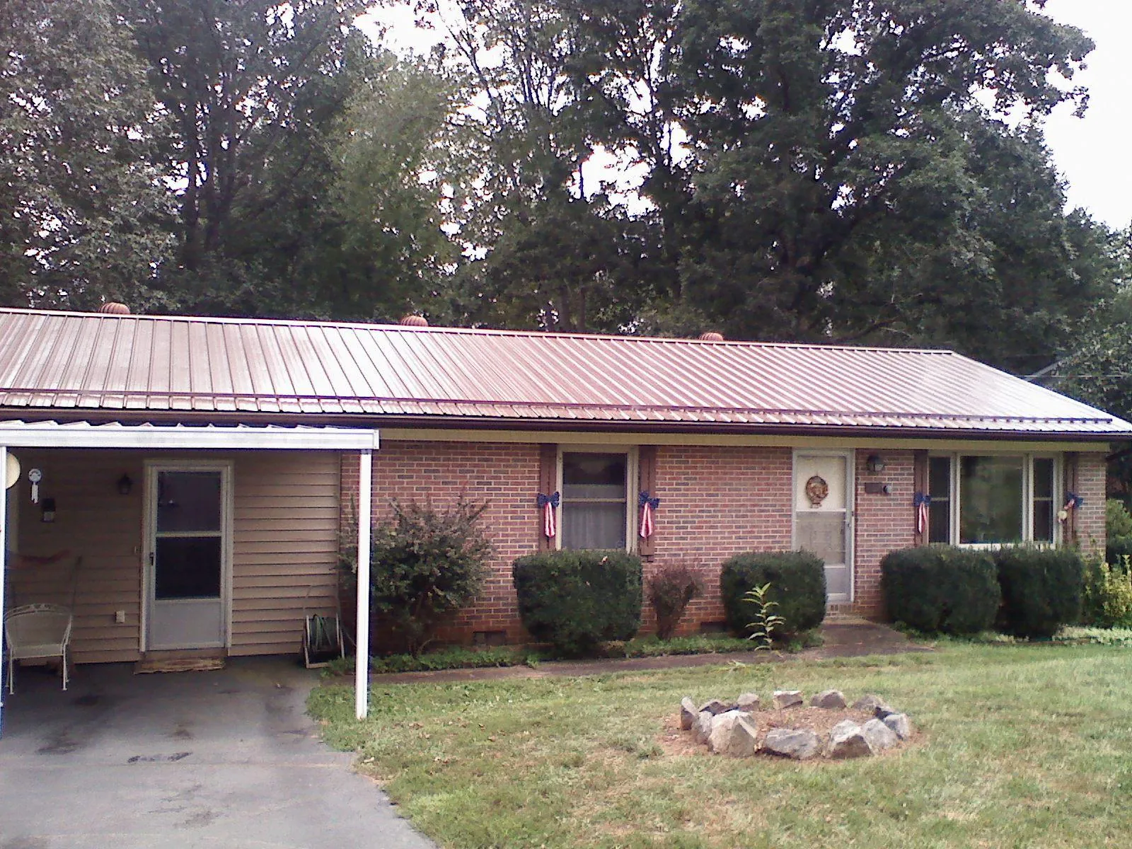 Bronze metal roof and carport on a brick ranch home — Roof Repair work by our crew in Freeburg